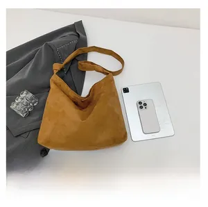 Macro shot of brown frosted suede tote bag showing soft texture and large interior space