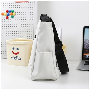 Vue détaillée du sac messager blanc montrant la poche latérale et la large bandoulière