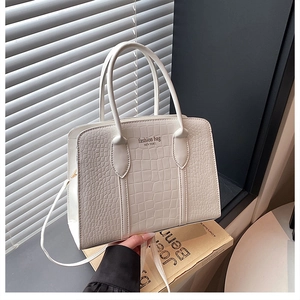 Detailed view of white crocodile embossed texture on a minimalist fashion tote bag