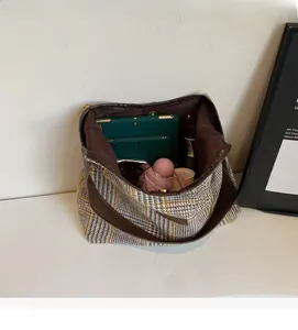 Detail showing spacious interior of the houndstooth tote bag with everyday items inside