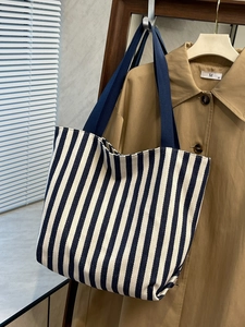 Detailed close-up of navy blue striped canvas tote bag texture with durable handles