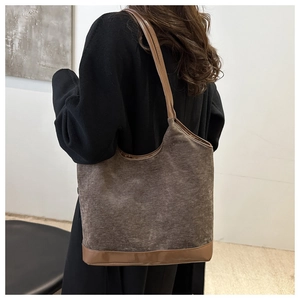 Detail of brown corduroy and leather patchwork tote bag on shoulder for daily commute