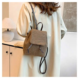 Detailed view of brown fleece backpack with premium leather straps on model's back