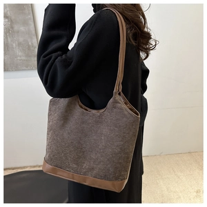 Detail view of brown canvas tote bag with leather straps and large capacity for women