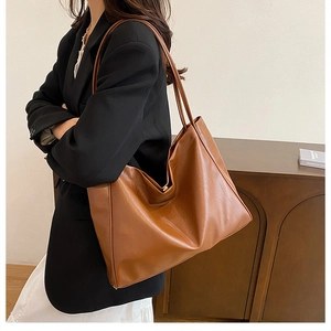 Detailed close-up showing the caramel brown PU leather texture of the large tote bag