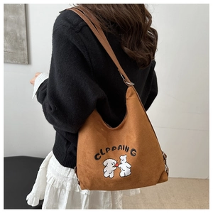 Detail view of a brown tote bag featuring cute dog embroidery on canvas material