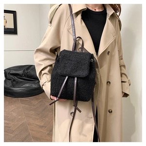 Close-up of black woolen backpack with leather straps on model in casual setting