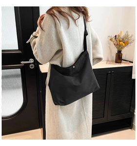 Detail of black matte fabric tote bag with magnetic button closure and sturdy strap