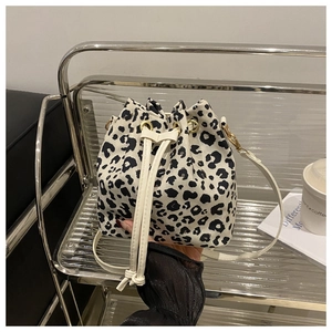 Detailed close-up of leopard print bucket bag with drawstring and white leather strap