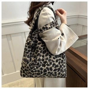 Vue détaillée du grand sac cabas en peluche léopard porté avec un élégant manteau en laine
