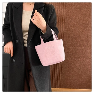 Close-up of pink pleated tote bag texture and wide handles on a winter coat