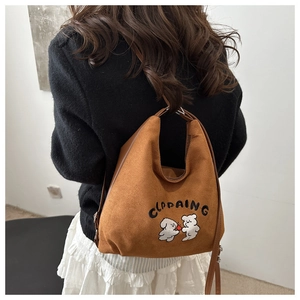 Caramel suede bucket bag featuring cute puppy embroidery and slim shoulder strap