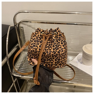 Detail of leopard print bucket bag with drawstring closure and brown leather strap