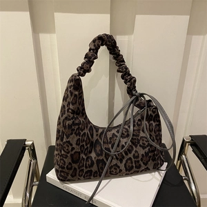 Vintage leopard print tote bag with ruched handle and side ties on a modern chair