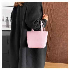 Close-up of pink tote bag showing the soft pleated leather texture and twin handles