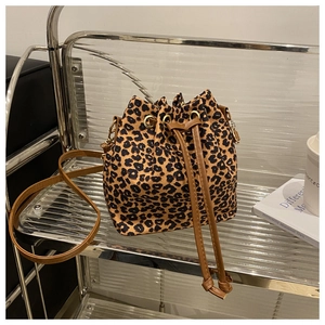 Detail of leopard print bucket bag with brown leather drawstring and metal eyelets