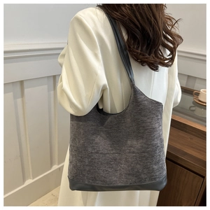 Detail of grey felt and leather tote bag styled with a white long winter coat