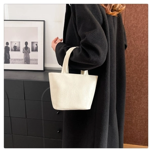 Close-up of a white minimalist square tote bag with soft leather texture for commuting