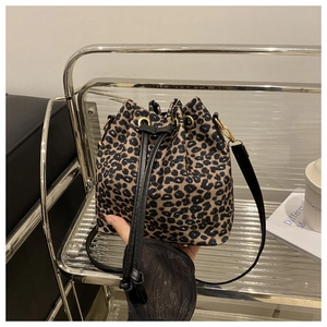 Detailed view of leopard print bucket bag with drawstring closure and golden hardware