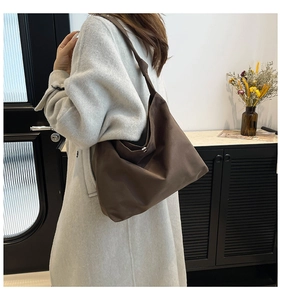 Detail showing the knotted strap design and matte texture of the brown tote shoulder bag