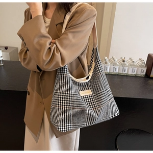 Detail of checkered tote bag showing the houndstooth pattern and fashion label patch