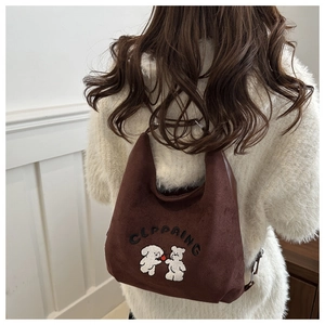 Detailed view of brown suede bucket bag featuring cute puppy and bear embroidery