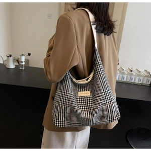 Detail of the large houndstooth tote bag featuring a Fashion & Bags label and wide strap