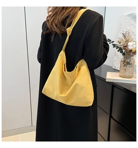 Detail of ginger tote bag featuring textured fabric with knotted shoulder strap and button