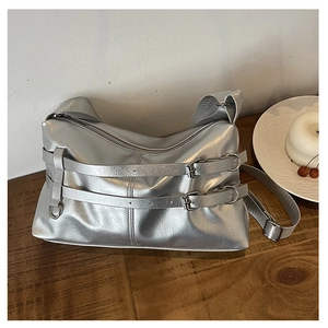 Detail of silver metallic leather handbag with dual straps and polished buckle hardware