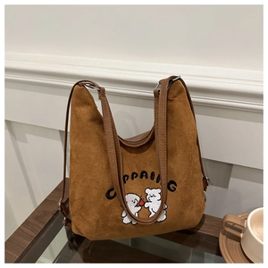 Detail of dark brown faux suede tote bag featuring bear embroidery and branding