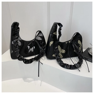 Detail of butterfly embroidery and ruffled handle on black shoulder bags for women