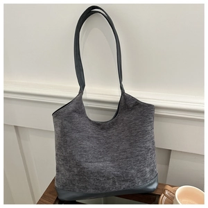 Detail of grey textured tote bag featuring knit fabric and leather bottom stitching