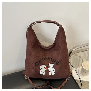 Detailed view of the brown suede tote bag featuring cartoon puppy and bear embroidery