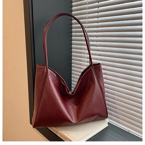 Detailed view of the dark burgundy PU leather texture on a large capacity tote bag