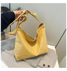 Close-up of yellow frosted velvet tote bag featuring stylish knot shoulder strap detail