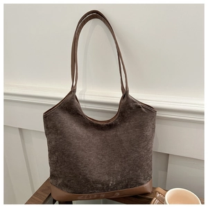 Close-up of deep brown corduroy tote bag showing textured fabric and faux leather base