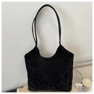 Detail of black velvet tote bag texture and smooth leather base for daily office use