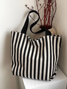 Close-up of thick striped canvas fabric and sturdy woven black handle for durability