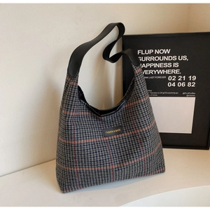 Close-up of large plaid tote bag showing woven texture and gold fashion logo label