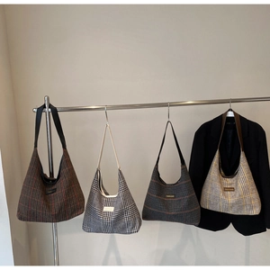 Selection of plaid hobo bags with wide straps in various colors hanging on a rack