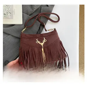 Detailansicht braune Wildledertasche mit goldenem Hirschdekor und Fransenverzierung