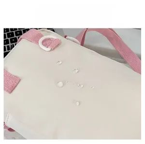 Close-up of waterproof nylon material on ita bag showing water droplets and pink strap