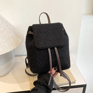 Minimalist black woolen backpack with plush texture and leather drawstring straps