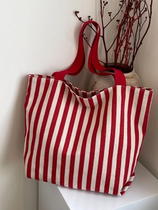 Detailed view of red and white striped canvas tote bag with reinforced handles and texture