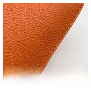 Macro shot of brown-orange litchi grain leather with detailed edge stitching craftsmanship