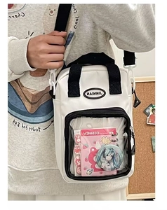 Detail view of white ita bag with transparent PVC window for anime badge display
