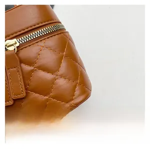 Close-up of brown quilted leather handbag with premium metal zipper and fine stitching