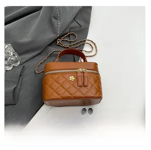 Detailed view of caramel quilted leather bag with floral gold hardware and chain strap