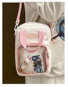 Detail of white mini ita bag with transparent front window and pink shoulder strap