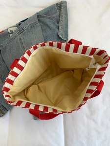 Top view of striped canvas tote showing yellow lining and white zipper closure details